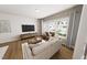 Cozy living room featuring a neutral sofa, modern furnishings, and a large window with neighborhood views at 3930 Willow Gate Way, Raleigh, NC 27604