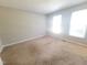 Large bedroom with neutral walls and carpet featuring two large windows at 4204 Labrador Dr, Raleigh, NC 27616