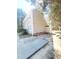 Side view of the home showcasing the neutral siding, brick foundation, and concrete parking area at 4204 Labrador Dr, Raleigh, NC 27616