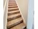 Staircase with neutral carpet and white trim, leading to the next level at 4204 Labrador Dr, Raleigh, NC 27616
