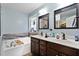 Primary bathroom featuring a dual vanity, soaking tub, and bright natural lighting at 47 London Ln, Angier, NC 27501