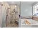 Beautiful primary bathroom featuring shower and tub with sleek fixtures and stone backsplash at 47 London Ln, Angier, NC 27501