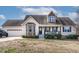 Charming home featuring a cozy front porch, well-maintained landscaping, and a convenient attached two-car garage at 47 London Ln, Angier, NC 27501