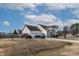 Suburban home featuring an attached garage, cozy front porch, and a driveway with parking for multiple vehicles at 47 London Ln, Angier, NC 27501