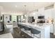 Modern kitchen boasts white cabinets, a large center island, and stainless steel appliances in an open-concept layout at 500 Trilith Pl, Durham, NC 27713