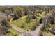 Scenic aerial view of wooded property featuring a unique stone and wood home with a red star marker on the roof at 524 N Occoneechee St, Hillsborough, NC 27278