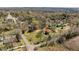 Expansive aerial view of a wooded property, showcasing a charming home marked with a red star on the roof at 524 N Occoneechee St, Hillsborough, NC 27278
