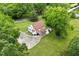 An aerial view of the back of the house with a small deck, surrounding landscaping, and a driveway at 524 N Occoneechee St, Hillsborough, NC 27278