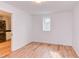 Neutral bedroom with wood flooring, window and access to washer and dryer at 524 N Occoneechee St, Hillsborough, NC 27278