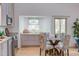 Dining area showcasing a glass table with upholstered chairs, adjacent to kitchen with grey cabinets at 524 N Occoneechee St, Hillsborough, NC 27278