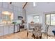 Modern kitchen featuring stainless steel appliances, gray cabinets, hardwood floors, and a stylish dining area at 524 N Occoneechee St, Hillsborough, NC 27278