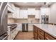 Well-lit kitchen with stainless steel appliances, white upper cabinets, and wooden lower cabinets at 525 Sanctuary Trl, Cameron, NC 28326