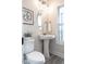 Charming powder room with pedestal sink, decorative mirror, and natural light at 525 Sanctuary Trl, Cameron, NC 28326