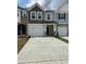 Charming multi-tone townhome featuring a one-car garage, neutral siding, and stone accents at 605 Leland Hl Cir, Zebulon, NC 27597