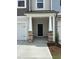 Inviting front porch with stone pillars and a black front door creates a charming entryway at 605 Leland Hl Cir, Zebulon, NC 27597