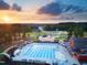 Aerial view of community amenities including pool, playground, barn clubhouse, green space, and mature trees at 63 Daybreak Way, Fuquay Varina, NC 27526