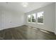 Bright bedroom with hardwood floors, natural light, and a serene view through three windows at 63 Daybreak Way, Fuquay Varina, NC 27526