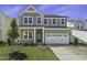 Charming two-story home with gray siding, a two-car garage, and a well-maintained lawn at 63 Daybreak Way, Fuquay Varina, NC 27526