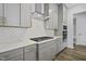 Close-up of kitchen with gray cabinets, stainless steel appliances, and decorative tile backsplash at 63 Daybreak Way, Fuquay Varina, NC 27526