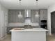 Kitchen featuring grey cabinets, stone countertops, and pendant lighting at 63 Daybreak Way, Fuquay Varina, NC 27526
