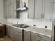 Stylish kitchen with gray cabinetry, sleek countertops, and stainless steel range hood at 63 Daybreak Way, Fuquay Varina, NC 27526