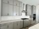 Kitchen featuring grey cabinets, stone countertops, and stainless range at 63 Daybreak Way, Fuquay Varina, NC 27526