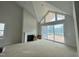Bright living room with fireplace, large windows, and vaulted ceiling at 63 Daybreak Way, Fuquay Varina, NC 27526