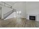 Open-concept living room features a staircase, fireplace, and plenty of natural light from large windows at 63 Daybreak Way, Fuquay Varina, NC 27526