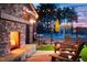 Outdoor lounge area featuring a stone fireplace and comfortable seating at 63 Daybreak Way, Fuquay Varina, NC 27526