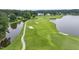 Scenic aerial view of a golf course with a water feature and sand traps surrounded by lush greenery at 632 Angus Ct, Sanford, NC 27332
