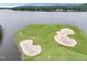 Stunning aerial shot showcasing a golf course and its well-manicured green, white sand traps, and lake at 632 Angus Ct, Sanford, NC 27332