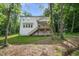 Picture of backyard with a wooden deck and stairs leading to a spacious, grassy lawn surrounded by mature trees at 632 Angus Ct, Sanford, NC 27332