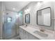 Modern bathroom featuring double vanity, quartz countertop, sleek mirrors, and a glass-enclosed shower with tiled walls at 632 Angus Ct, Sanford, NC 27332
