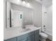 Bathroom featuring blue vanity, quartz countertop, large mirror, tiled shower/tub combo, and modern fixtures at 632 Angus Ct, Sanford, NC 27332