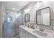 Modern bathroom featuring double sinks, sleek mirrors, and a glass-enclosed shower with tile surround at 632 Angus Ct, Sanford, NC 27332