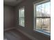 Sunlit bedroom featuring two large windows providing natural light and views of the backyard landscape at 632 Angus Ct, Sanford, NC 27332