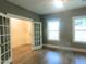 Bedroom with hardwood floors, large windows, and French doors leading to another room at 632 Angus Ct, Sanford, NC 27332