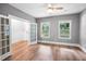 A bedroom with gray walls, wood floors, ceiling fan, and french doors to another room at 632 Angus Ct, Sanford, NC 27332