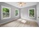 Bedroom with a ceiling fan and carpeted floors illuminated by natural light from three windows at 632 Angus Ct, Sanford, NC 27332