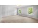 Bedroom with board and batten accent wall, two windows, and neutral carpet at 632 Angus Ct, Sanford, NC 27332