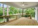 Relax on this covered wooden deck with black metal railing offering scenic views of the surrounding green landscape at 632 Angus Ct, Sanford, NC 27332