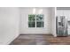 Dining area with wood floors, a modern chandelier, and a window overlooking a wooded area at 632 Angus Ct, Sanford, NC 27332