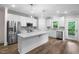 Bright kitchen boasts white cabinets, stainless steel appliances, large island and pendant lighting at 632 Angus Ct, Sanford, NC 27332