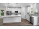 A modern kitchen with white cabinets, stainless steel appliances, and a large center island at 632 Angus Ct, Sanford, NC 27332