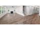 Bright living room featuring wood floors, fireplace, windows, and staircase with modern black metal railing at 632 Angus Ct, Sanford, NC 27332