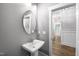 Charming powder room featuring a pedestal sink, oval mirror, and modern fixtures at 632 Angus Ct, Sanford, NC 27332