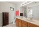 Bright bathroom featuring a double sink vanity with wood cabinetry and framed mirror at 634 Conover Rd, Durham, NC 27703