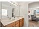 Bright bathroom featuring a double sink vanity with wood cabinetry and framed mirror at 634 Conover Rd, Durham, NC 27703