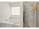 Bright bathroom featuring a soaking tub and shower behind a glass partition at 634 Conover Rd, Durham, NC 27703