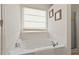Clean bathroom featuring a soaking tub with a shower behind a glass partition at 634 Conover Rd, Durham, NC 27703